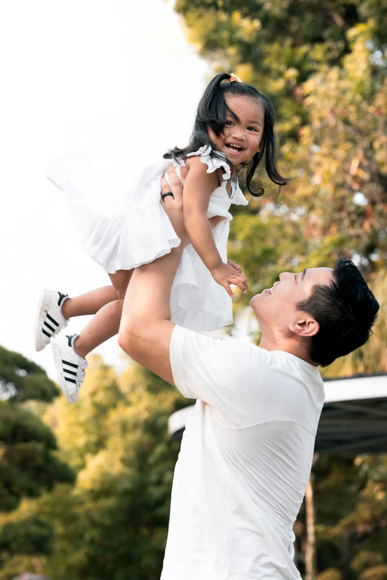 Dan lifting Gabby high into the air as she laughs with delight